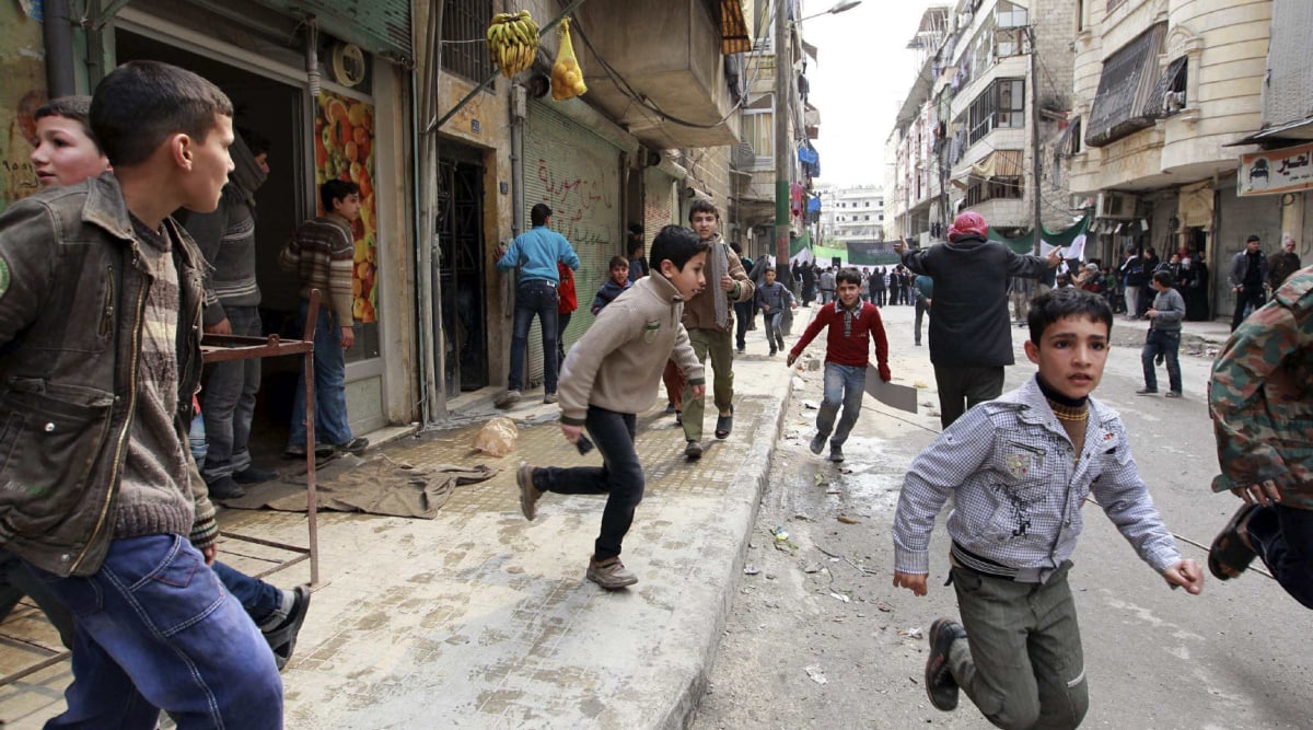 People run upon hearing a nearby plane bombing during a protest against Syrian President al-Assad in Aleppo